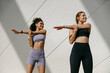 Smiling women does warm-up exercises in morning before running training outside. Healthy fitness