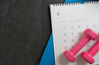 Time for exercising equipment dumbbell and calendar with black background, sport and healthy concept
