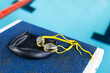 Swimming goggles and cap resting on pool edge indoors
