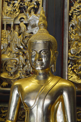 Wall Mural - golden buddha statue on a wall background.