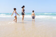 © Inna Reznik/Stocksy - Family Enjoying Sunny Day At The Beach,Children Playing In Shorebreak.