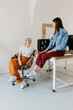 © Mihajlo Ckovric/Stocksy - Two female coworkers having fun in the office talking