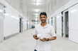 © Daniel Gonzalez/Stocksy - Happy man standing with security camera in hall