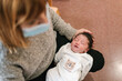 © Ezequiel Giménez/Stocksy - Crop woman placing newborn baby on laps in hospital