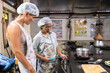© Alvaro Lavin/Stocksy - Two women cooking in the kitchen.