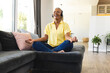 © Wavebreak Media - African American senior woman sitting cross-legged at home, meditating