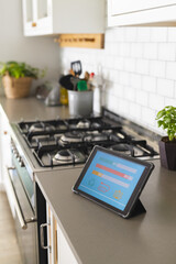Smart home app energy usage on tablet in kitchen at home