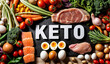A display of various keto healthy diets foods, including eggs, meat, fish and vegetables. The word text KETO is written in white on a black surface