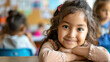 Happy Hispanic girl learning during class at elementary school and looking at camera.