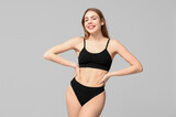 Fototapeta Mapy - Beautiful young woman in black cotton underwear on light background