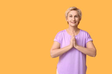 Sticker - Portrait of meditating mature woman on yellow background