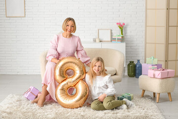 Canvas Print - Beautiful young woman and her cute little daughter with air balloon in shape of figure 8 in living room