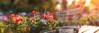  Shopping cart with many packages on a laptop desktop and blurred blooming flowers garden defocused bokeh effect with sun light in the background for online shopping concept. 
 