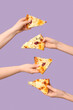 Many hands holding tasty pizza slices on lilac background