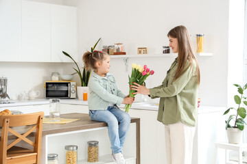 Sticker - Little girl sitting on table and greeting her mom with Mothers Day in kitchen