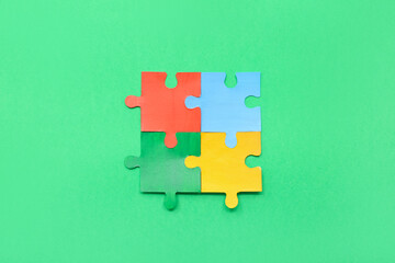 Color puzzle on green background. Concept of autistic disorder