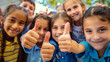 © aekkorn - Group of school kids showing thumbs up.