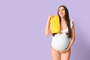 Poster - Young pregnant woman in swimsuit with towel on lilac background. Travel concept