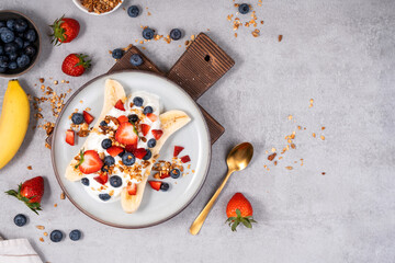 Wall Mural - Healthy Banana Split Breakfast with Yogurt, Granola and Fresh Berries