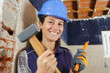 happy female builder holding a hammer