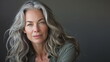 Serene middle-aged woman with wavy grey hair. Great for age positivity, natural beauty topics.
