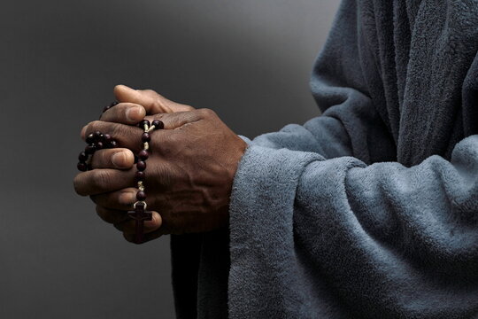 praying to god with hands together Caribbean man praying on black background with people stock photos stock photo stock image