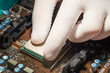 Man hand in white antistatic gloves installing computer processor