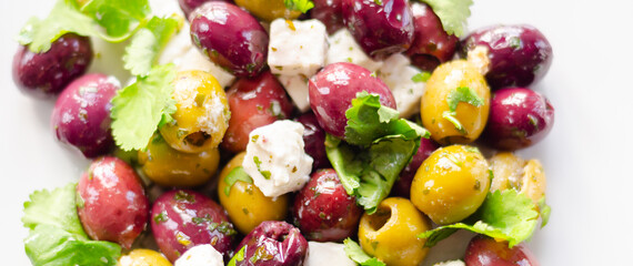 Fresh Greek salad based on green and black olives with pieces of white feta cheese and parsley