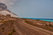 Dirt road along the ocean. Emerald water, pristine beaches, wild rocky shores. Amazing landscape. Yemen. Socotra.