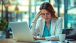 © LukaszDesign - Stress, exhaustion, and doctor visits Hospital woman with a headache using a laptop. Mental health, medicine, and clinic with a female doctor