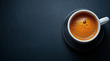 Fototapeta Mapy - White coffee cup on dark surface. Top view. Isolated on dark background. Room for copy space.	