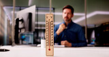 Fototapeta Panele - Thermometer In Front Of Businessman Working During Hot Weather