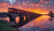 Train crossing river bridge at sunset, reflecting on water under dusk sky