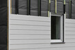 wood texture composite cladding installation on house facade. WPC exterior wall siding panels