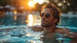 © antkevyv - Pool, man in swimming pool at sunset, leisure activity sunglasses enjoyment fun sun