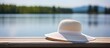 A straw hat on a wooden pier by a lake
