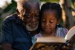Elderly man sharing a story from a book with his young granddaughter under natural light