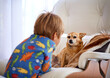 Home, couch and kid with dog as pet in living room for fun, play and bonding with child development. Back view, animal and puppy in sofa at lounge for care with support, love and childhood memories.