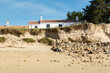 Recul d'une dune menaçant des maisons, suite à la hausse du niveau de la mer entrainant une érosion importante