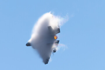 Wall Mural - Very  close view of a F-35C Lightning II  in a high G turn, in a condensation cloud, with afterburner on