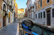 Narrow canal with gondola and bridge in Venice, Italy. Architecture and landmark of Venice. Cozy cityscape of Venice.