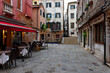 Old street with tables of restaurant in Venice, Italy. Architecture and landmark of Venice. Cozy cityscape of Venice.