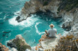 An image of an artist painting the seascape from a cliff, capturing the ever-changing colors and moo