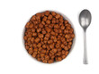 Chocolate breakfast cereal, top down view in a white bowl with spoon isolated on a white background