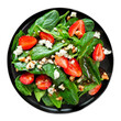 Summer salad of spinach, strawberries and blue cheese in a black plate isolated on a white background