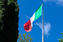 Una Bandiera Italiana Sventola In Cima A Un Pennone, Con Il Cielo Blu Sullo Sfondo.