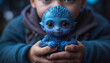 A little boy holds a small blue alien in his hands