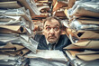 A surprised businessman sits at his desk, completely overwhelmed by towering stacks of papers and documents.