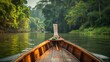 A traditional Thai longtail boat cruising along a tranquil river, with lush greenery lining the banks and the sound of birdsong filling the air.