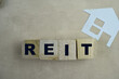 Concept of REIT - Real Estate Investment Fund The wooden Cubes with the word on wooden background.